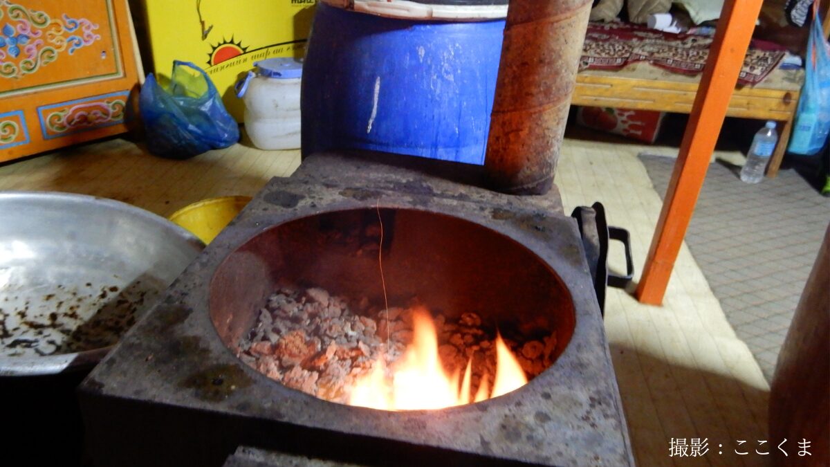 モンゴルゲル内のストーブで牛糞を燃やしているところ